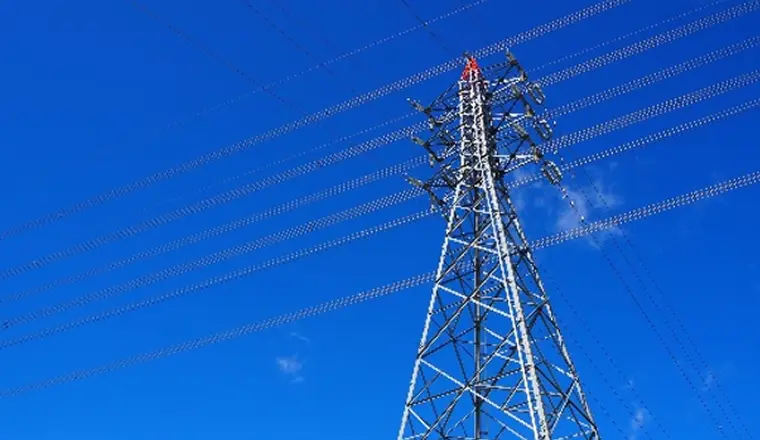 青空を背景に送電鉄塔と送電線が伸びる写真。
