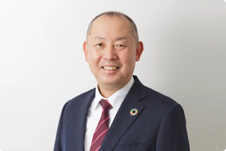 スーツ姿で正面を向いて微笑んでいる社長