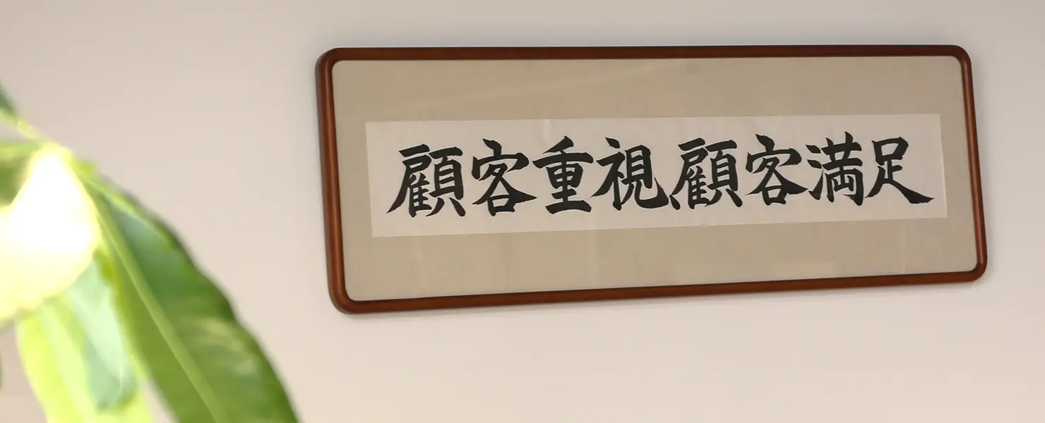 壁に飾られた書の額。「顧客重視顧客満足」と書かれている。