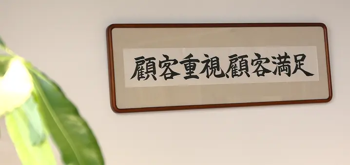 壁に飾られた書の額。「顧客重視顧客満足」と書かれている。