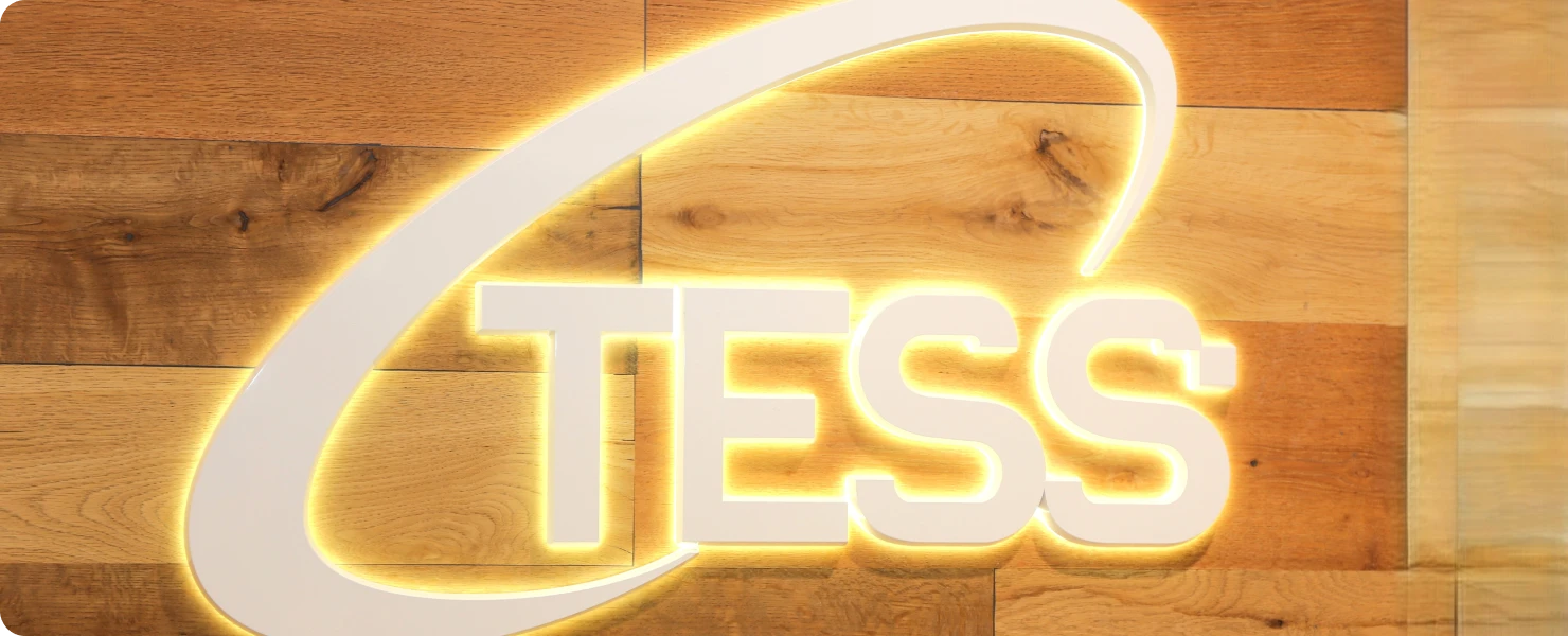 木製の壁に設置された、光るTESSのロゴ