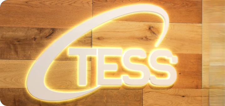 木製の壁に設置された、光るTESSのロゴ