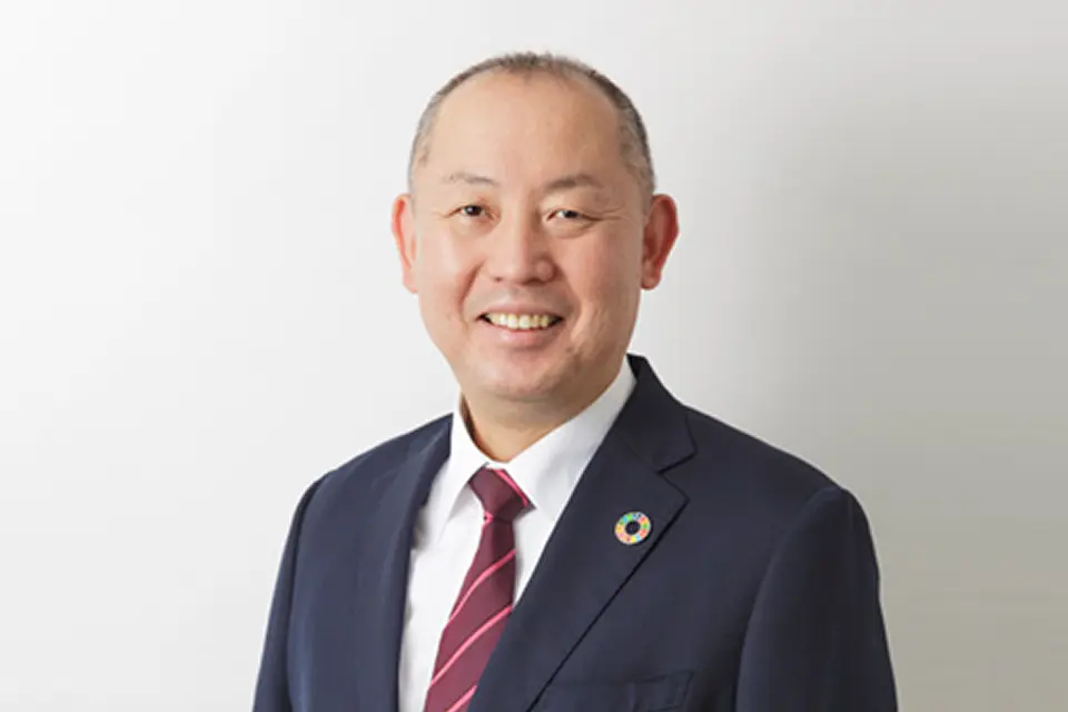 スーツ姿で正面を向いて微笑んでいる社長