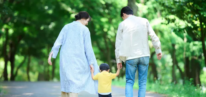 家族が手を繋いで歩いている画像