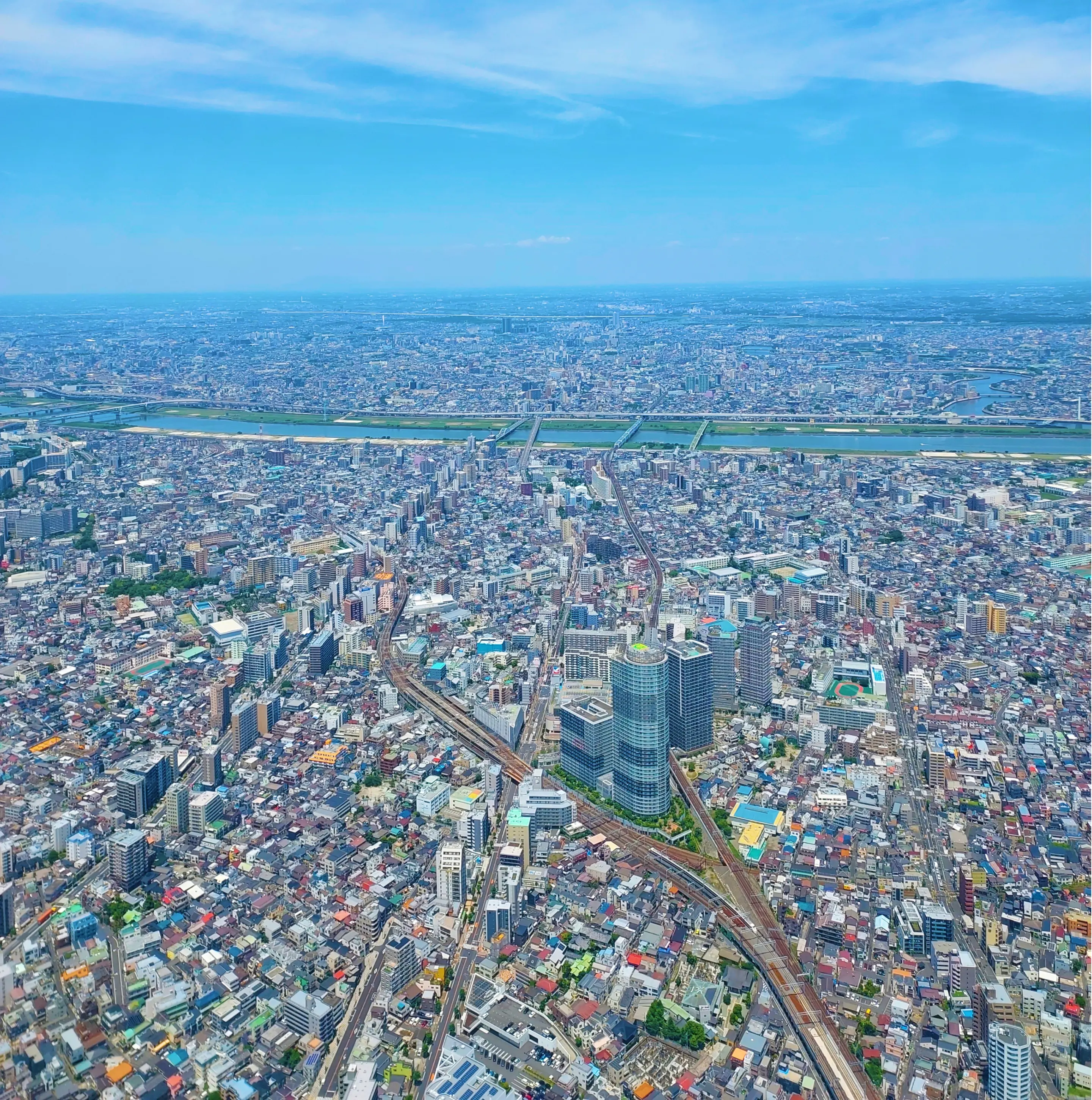 都市のビル群を上空から見下ろした背景写真。